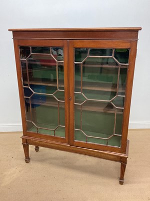 Lot 610 - A bookcase, with glazed doors, three shelves,...