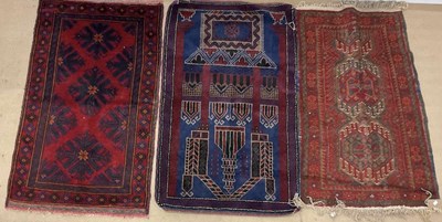 Lot 555 - A red Persian rug and two Afghan Baluch style...
