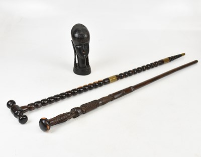 Lot 1 - Two African hardwood walking sticks, larger...