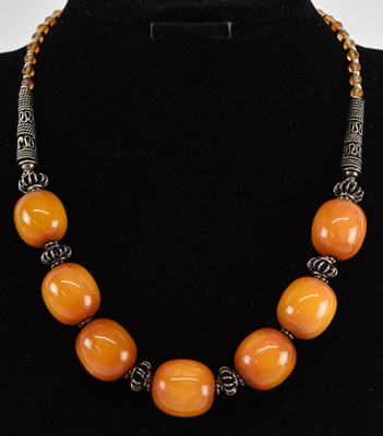 Lot 1221 - An amber effect seven bead white metal mounted...