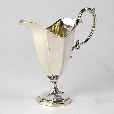Lot 907 - A George V hallmarked silver helmet-form cream...
