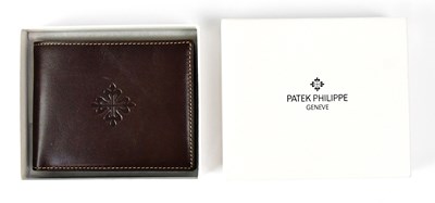 Lot 363 - PATEK PHILIPPE; a branded brown leather wallet,...