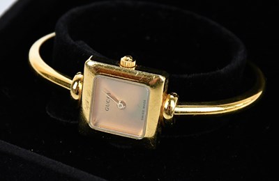Lot 794 - GUCCI; a gold tone square Swiss made quartz...