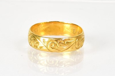 Lot 1020 - A 22ct yellow gold wedding band with foliate...