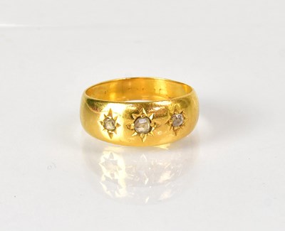 Lot 1022 - A 22ct yellow gold ring set with three...