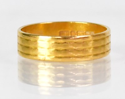 Lot 1023 - A 22ct yellow gold ring with engraved line...