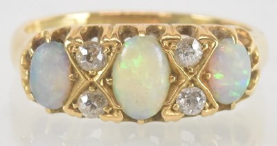 Lot 1148 - An 18ct yellow gold opal and diamond set ring,...