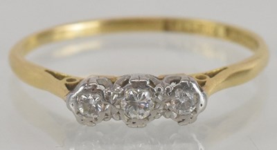 Lot 1153 - An 18ct yellow gold and platinum three stone...