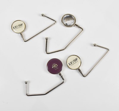 Lot 1473A - Four contemporary handbag clips/hangers each...