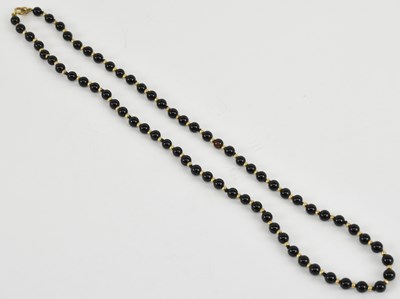 Lot 1214 - A single strand onyx bead necklace, with 9ct...