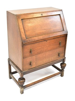 Lot 90 - A 1940s oak bureau, the fall front enclosing a...