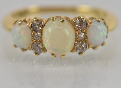 Lot 1158 - An 18ct yellow gold opal and diamond three...