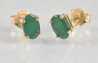 Lot 1252 - A pair of 9ct yellow gold emerald set ear...