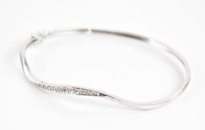 Lot 249 - A 9ct white gold diamond set shaped hinged...