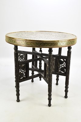 Lot 1841 - An Eastern brass topped folding circular table,...