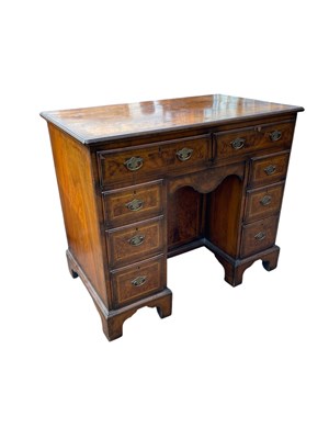 Lot 2129 - A George III style walnut knee hole desk, with...