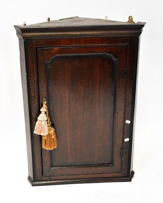 Lot 103 - A Georgian oak wall-hanging corner cupboard...