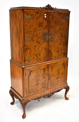 Lot 108 - A 1930s walnut drinks cabinet, with ornate...