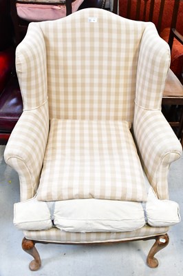 Lot 38 - A 20th century wingback armchair raised on...