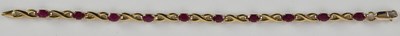 Lot 1607 - A 9ct gold bracelet with ten claw set rubies...