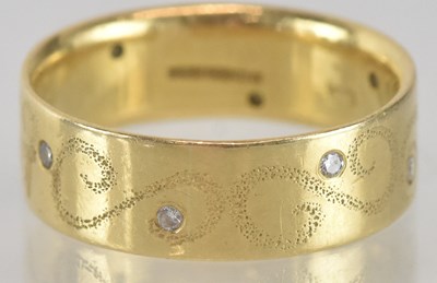 Lot 1282 - An 18ct gold band ring, with offset tiny...