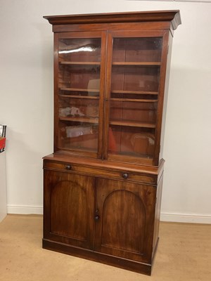 Lot 707 - A mahogany glazed bookcase over cupboard,...