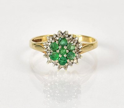 Lot 1042 - A 9ct gold cluster ring set with emeralds and...