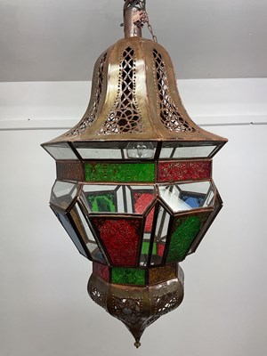 Lot 663 - A Moroccan metal and glass panelled pendant...