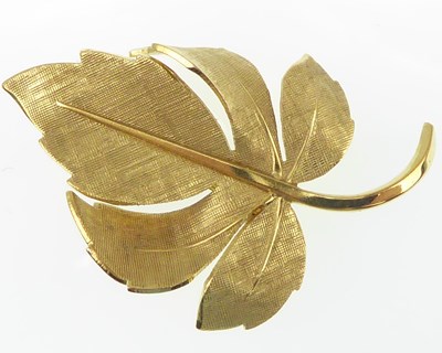 Lot 1135 - A 9ct gold modern leaf brooch with textured...