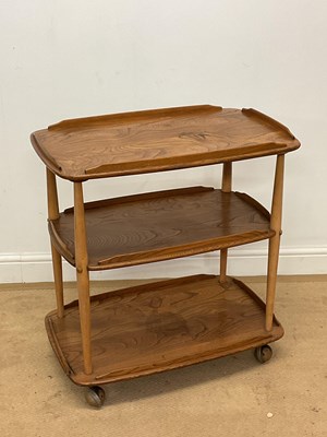 Lot 756 - ERCOL; an elm and beech three tier trolley on...