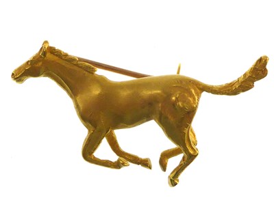 Lot 1137 - A 9ct gold brooch in the form of a galloping...