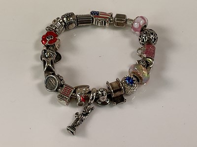 Lot 580 - PANDORA; a charm bracelet set with numerous...