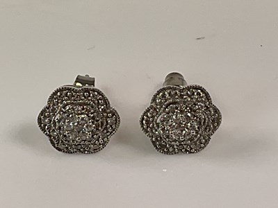 Lot 574 - A pair of 9ct white gold diamond set flower...