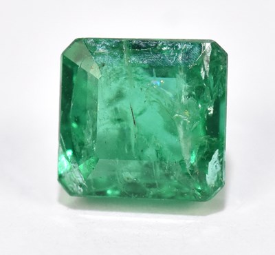 Lot 1520 - An unmounted square cut loose emerald weighing...
