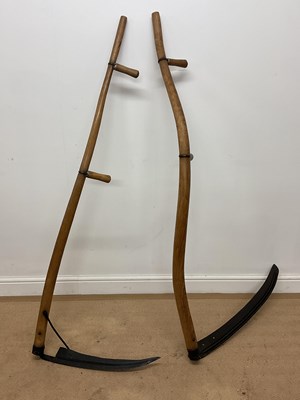 Lot 676 - Two ash handled scythes, length 158cm.