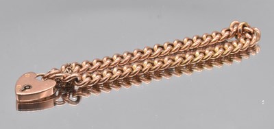 Lot 555 - A 9ct gold curb link bracelet with padlock...