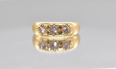 Lot 548 - An 18ct yellow gold three stone diamond ring...