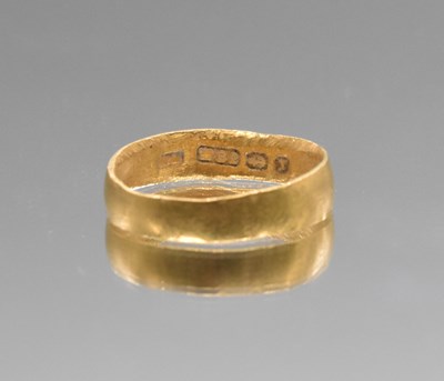 Lot 561 - A 22ct yellow gold wedding band (misshapen),...
