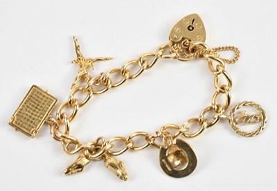 Lot 220 - A 9ct yellow gold charm bracelet, with five...