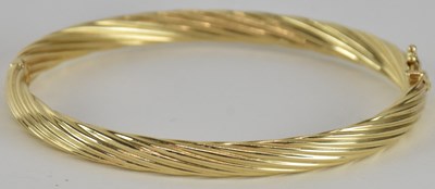 Lot 1600 - A yellow gold hinged bracelet with box clasp...