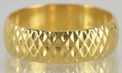 Lot 1247 - A 22ct yellow gold wedding band, with textured...