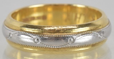 Lot 1253 - An 18ct white and yellow gold wedding band,...