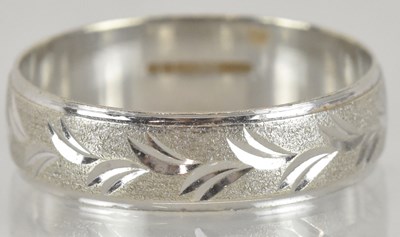 Lot 1347 - A 9ct white gold wedding band, with textured...