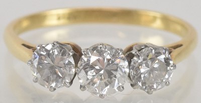 Lot 1148 - An 18ct gold three stone diamond set ring, the...