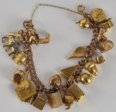 Lot 1579 - A 9ct gold charm bracelet, with twenty-five...