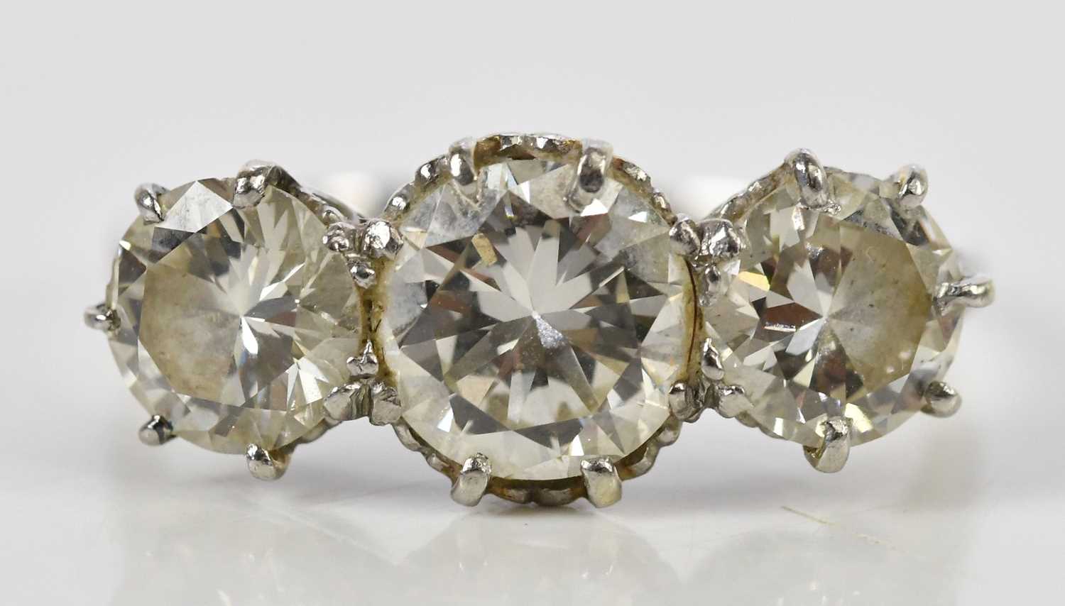 Lot 41 - A white metal three stone graduated diamond...