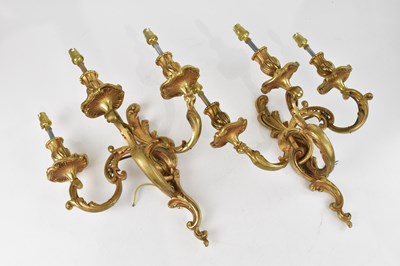 Lot 2411 - A pair of gilt metal Rococo style three branch...