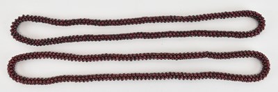 Lot 1464 - Two interwoven garnet bead necklaces, both...