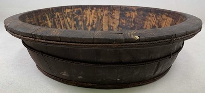 Lot 90 - A large stained pine wooden bowl, bound and...