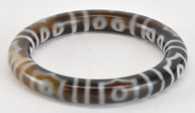 Lot 1624 - A banded agate bangle, with white decoration,...